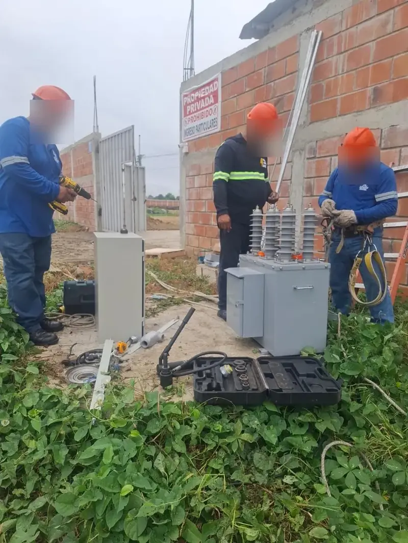 Cuadrilla preparando un equipo trifásico de media tensión antes de montarlo